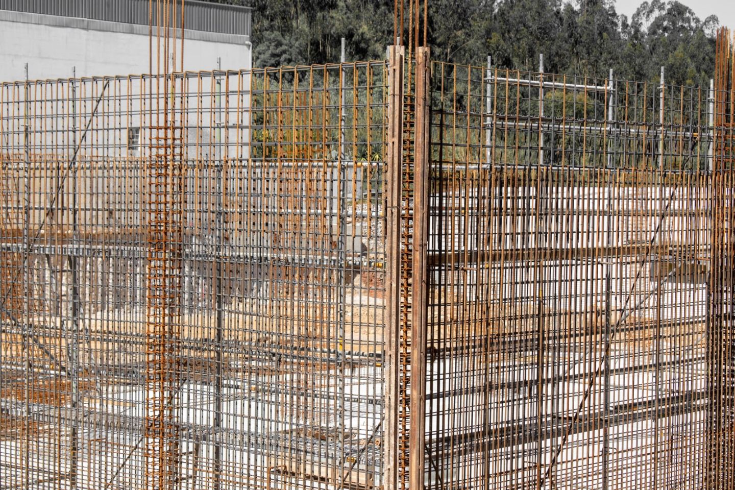 Dicht gestellte Bewehrungsmatten und Holzschalung auf einer Baustelle vor dem Betonieren.